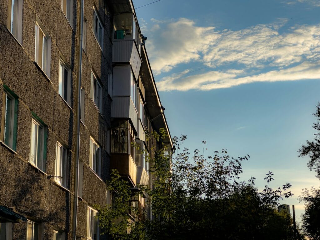 Multifamily apartment building exterior with a surface parking area suited for detached ADU conversion